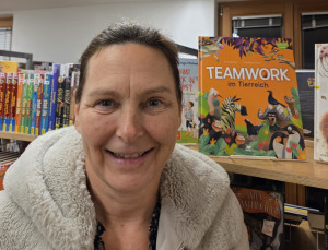 Mann steht im Raum uns spricht über ein projiziertes Bild an der Wand